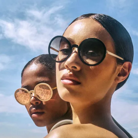 deux femmes portant des lunettes de soleils rondes LIndberg modèle Now couleur noir et beige